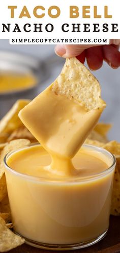 a person dipping cheese into a small bowl with tortilla chips on the side