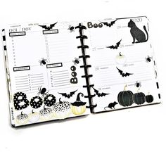 an open halloween planner with black cats and pumpkins