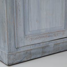 an old white painted cabinet with peeling paint on it's doors and bottom panel