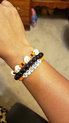 a person wearing a bracelet with beads on their wrist and the word slow written on it