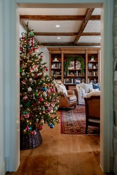 a christmas tree in the middle of a living room with lots of bookshelves