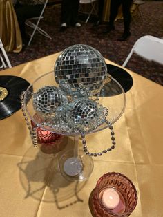 disco ball centerpiece with candles and record on table