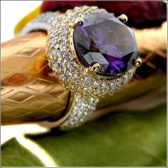 One of a kind exquisite ring set with AAA high quality oval amethyst color center stone in prong setting in 18K yellow gold top, domed band is covered with small pave set stones in platinum  StoneSize:  5ct. center 2ct. sides TCW 7 Stone Shape:  Oval/Round Metal:  18K Gold & Platinum Two Tone