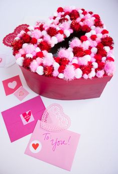 valentine's day card box with tissue paper and pom - poms