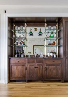 a wooden cabinet filled with lots of bottles and glasses