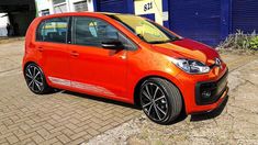 an orange car parked in front of a blue building