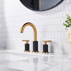 a bathroom sink with gold faucet and marble counter top