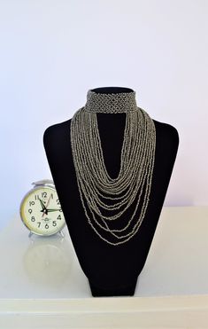 Unique Africa Maasai Handcrafted Beaded Necklace with an Elegant Look and Brilliant Finish. Color = Silver Gray. Length (Around Neck) = Adjustable. Length ( Downwards ) = 11.5 Inches / 30 Centimeters. **GET FREE SHIPPING FOR ADDITIONAL ITEMS PURCHASED. Yes, Buy Multiple Items and pay shipping for 1 item only- The rest ships Free. (No Limits on the number of Multiple items). With a faster delivery time of 3 days via DHLExpress, Worldwide. Ordinary/Standard Shipping also available upon request. We Silver Chain Choker For Festivals, Adjustable Silver Chain Necklace For Festivals, Silver Beaded Layered Necklace As Gift, Silver Beaded Layered Necklace For Gift, Elegant Silver Chain Necklace For Festival, Bohemian Silver Layered Choker Necklace, Silver Bohemian Layered Choker Necklace, Silver Bohemian Choker For Party, Beaded Silver Layered Necklace For Party