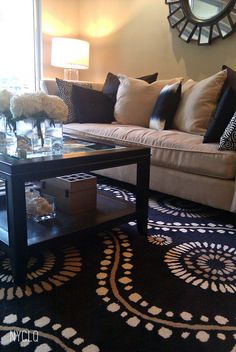 a living room filled with furniture and a large clock mounted on the wall above it