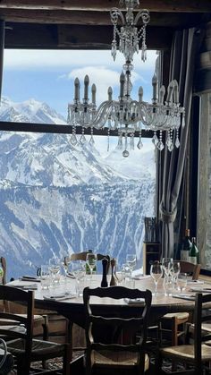 a dining room table with chairs and a chandelier hanging from it's ceiling