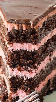 a piece of chocolate cake with pink and white frosting