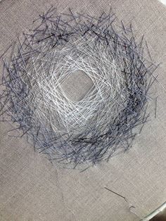 a close up of a piece of cloth on a table with yarn in the center