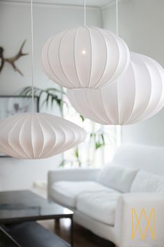 three white lamps hanging from the ceiling in a living room