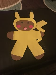 a paper cut out of a person wearing a yellow costume on top of a book