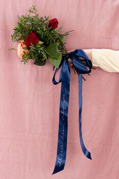 a bouquet of flowers tied to a pink wall