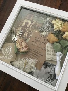 a framed photo with flowers and other items in it