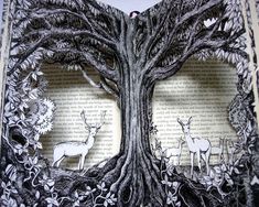 an open book with paper cut out of the pages and deers in the trees