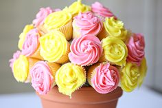 cupcakes with pink and yellow frosting in a vase