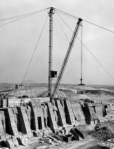 an old black and white photo of a crane in the middle of construction on top of a building