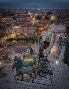 an aerial view of the city at night, with horses and carriages in the foreground