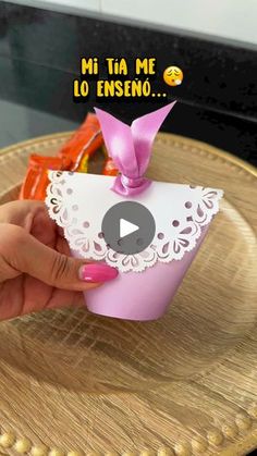 a person is holding a small cup with a pink bow on it and the words mi ta me lo enseno in spanish