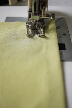 the sewing machine is working on the yellow fabric that's being sewn down