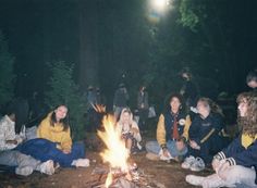 a group of people sitting around a campfire