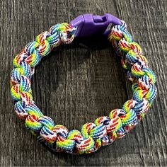 a multicolored bracelet sitting on top of a wooden table