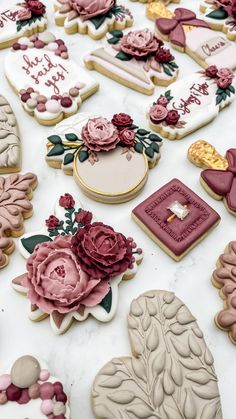 many decorated cookies are on a table with flowers and hearts in the middle one cookie has been cut out to say happy birthday