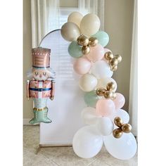 a balloon arch is decorated with balloons and a nutcracker figurine on it