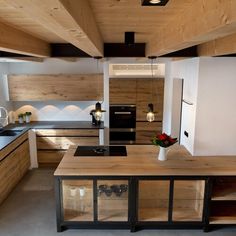 a kitchen with an island counter and wooden cabinets in the center is lit by lights