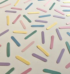 colorful confetti sprinkles are scattered on a white surface