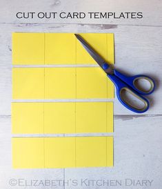 cut out card templates with scissors on top of them and yellow paper in the middle