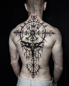 a man's back with an intricate tattoo on it