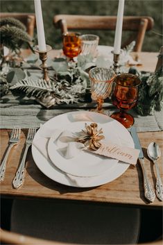 a table set with white plates and silverware