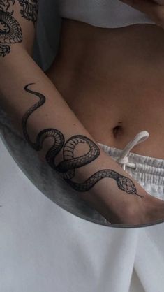 a woman with a snake tattoo on her arm