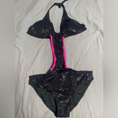 a black and pink bikinisuit laying on top of a white sheet