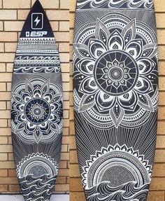 two skateboards with designs on them sitting next to a brick wall