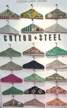 an advertisement for cotton and steel clothing hanging from hooks on a white wall in front of a window