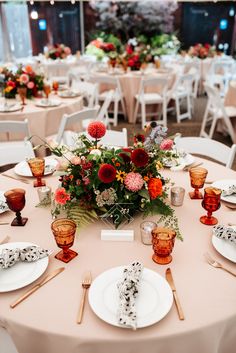 an image of a table setting with place settings and flowers on the centerpieces