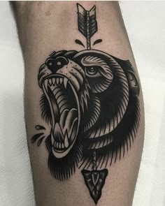 a black and white bear with an arrow tattoo on his leg, showing it's teeth