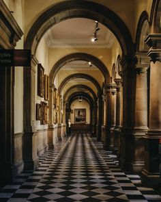 an arched hallway with black and white checkered flooring in the foreground, framed by ornate archways