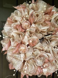 a wreath is hanging on the front door with pearls and ribbon around it's edges