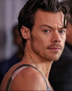 a close up of a person wearing a tank top and looking off to the side