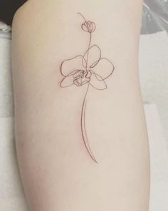 a small flower on the side of a woman's thigh, which is drawn in black ink