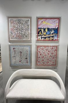 a white bench sitting in front of three paintings