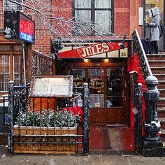 a restaurant with stairs and snow falling on the ground