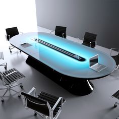 a conference table with chairs around it and a laptop on the top that is lit up