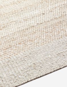 an area rug with white and beige colors on the floor, closeup view from above