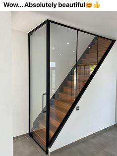 an image of a stair case with glass doors on the bottom and wood handrails